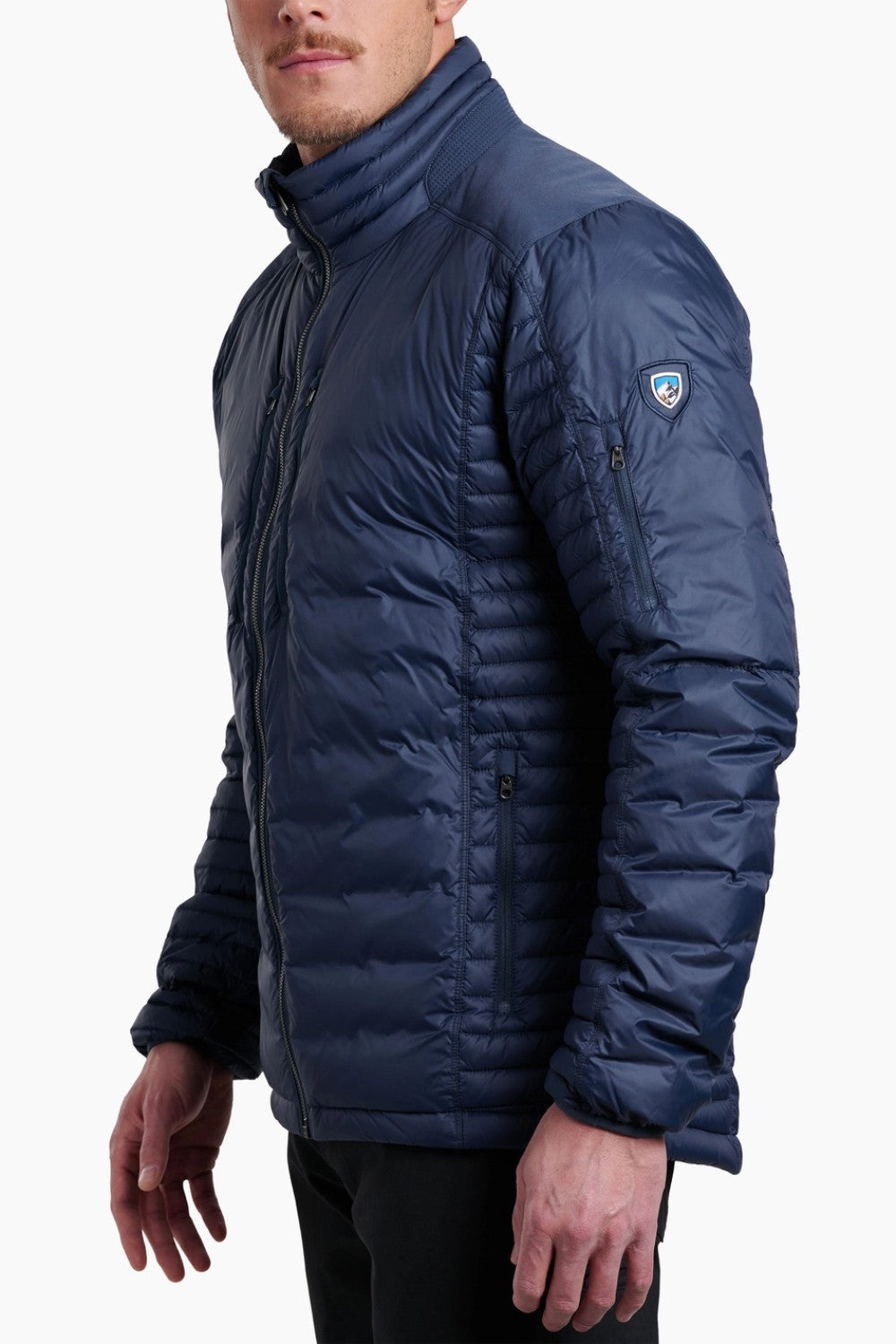 Man wearing a blue puffer jacket with a brand logo on a white background