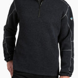 Man wearing a dark gray fleece pullover with a brand logo on a white background