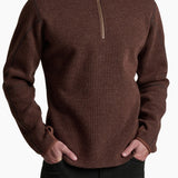 Man wearing a brown zip-up sweater against a white background