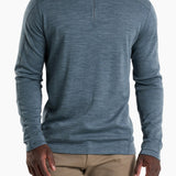 Man wearing a blue long-sleeve shirt with a quarter zip on a white background