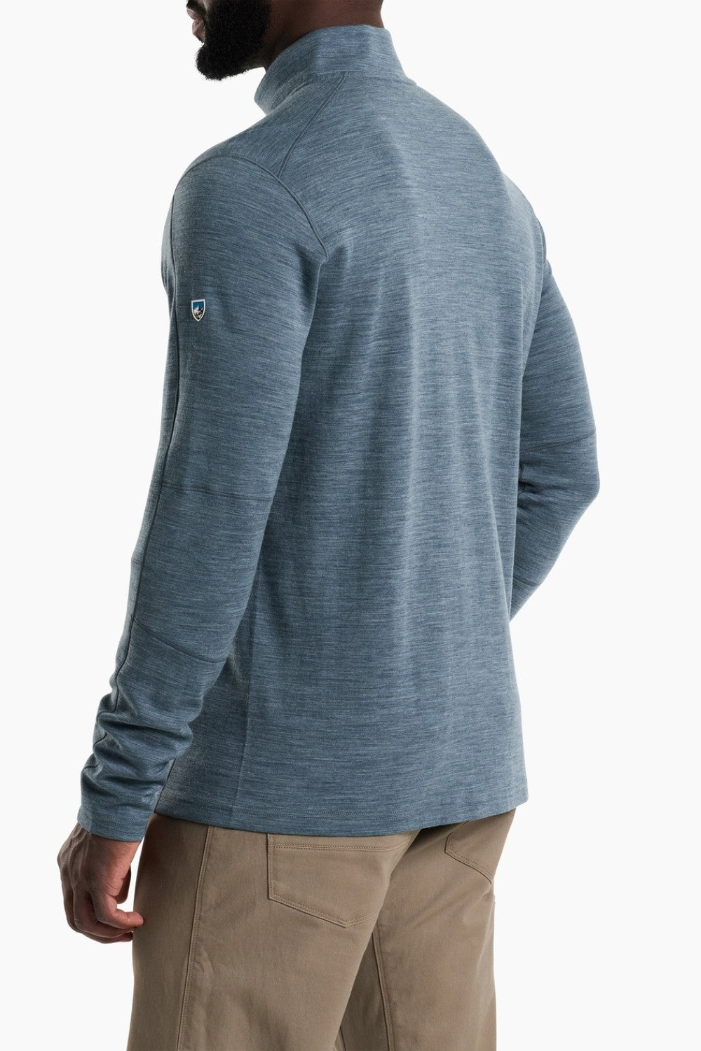 Person wearing a blue long-sleeve shirt with a brand logo on a white background