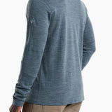 Person wearing a blue long-sleeve shirt with a brand logo on a white background