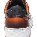 This cognac leather sneaker features a sleek design complemented by stylish white trim, making it a versatile addition to any wardrobe. Made from high-quality materials, it offers both durability and comfort, ideal for casual outings or everyday wear. The combination of classic black and crisp white ensures a modern aesthetic, while the sneaker's lightweight construction offers ease of movement. Perfect for those seeking a blend of fashion and functionality.