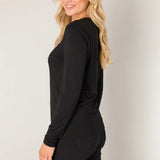 Woman wearing a black outfit against a plain background