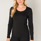 Woman wearing a black long-sleeve top and black pants against a plain background