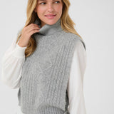 Woman wearing a gray knitted vest over a white shirt on a white background