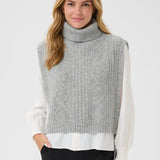 Woman wearing a gray knitted vest over a white shirt on a light gray background