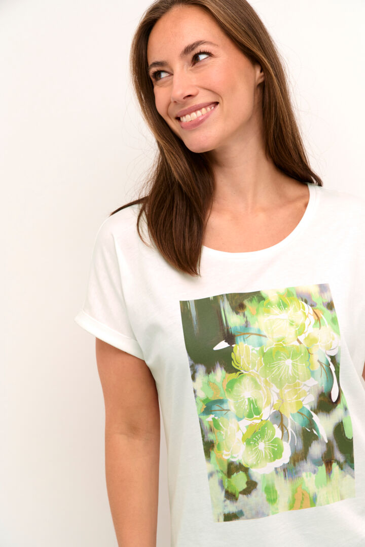 Stay cool and stylish with our Cream Irma T-Shirt. Made from 100% cotton, this tee features a vibrant green flower print. Perfect for any casual occasion, this shirt will become a staple in your wardrobe. (Seriously, it's a must-have!)