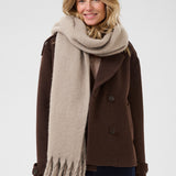 Woman wearing a brown coat and beige scarf on a white background