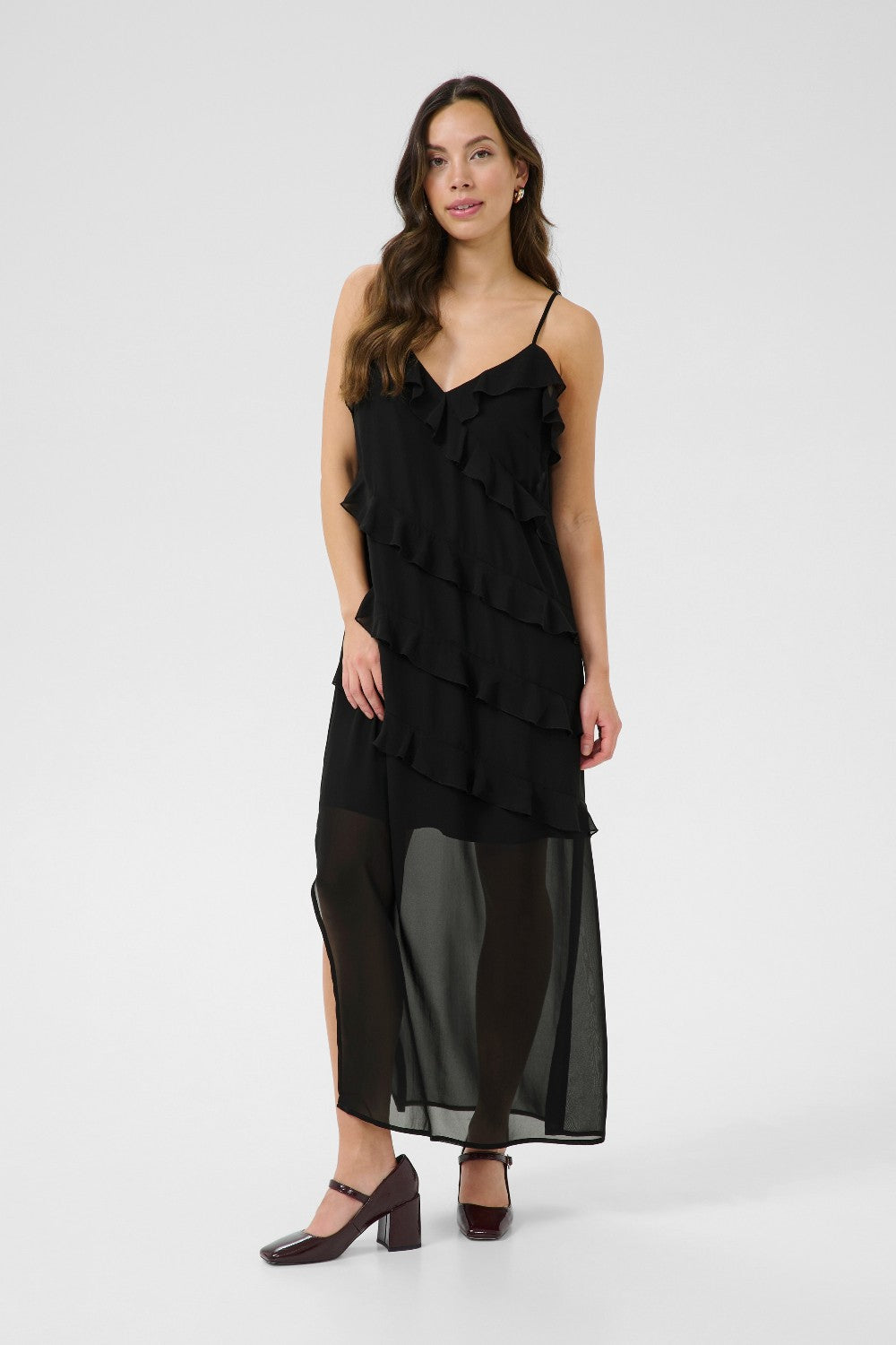 Woman wearing a black ruffled dress on a white background