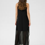 Woman wearing a black dress with sheer overlay on a white background