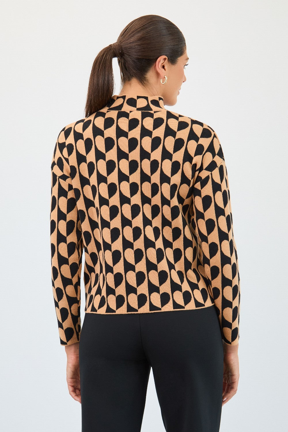 Woman wearing a patterned blouse with black and beige design on a white background