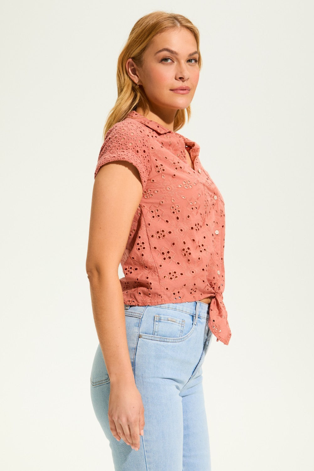 This 100% cotton top exudes effortless style with its eyelet lace detailing and playful tie at the front. A versatile choice for any casual occasion.