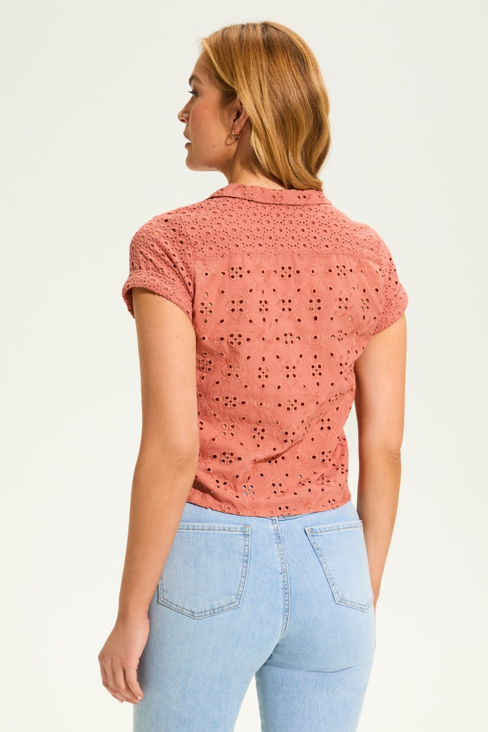 This 100% cotton top exudes effortless style with its eyelet lace detailing and playful tie at the front. A versatile choice for any casual occasion.