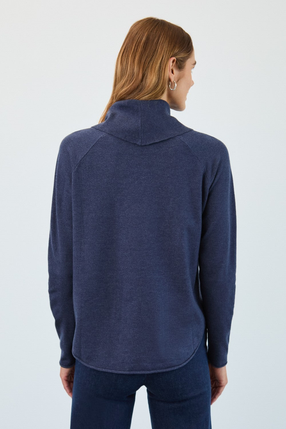 Person wearing a navy blue sweater on a white background