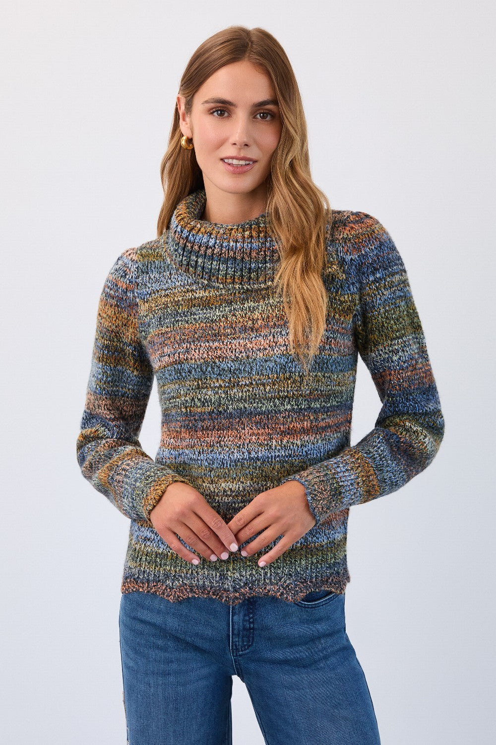 Woman wearing a multicolored sweater and blue jeans on a white background