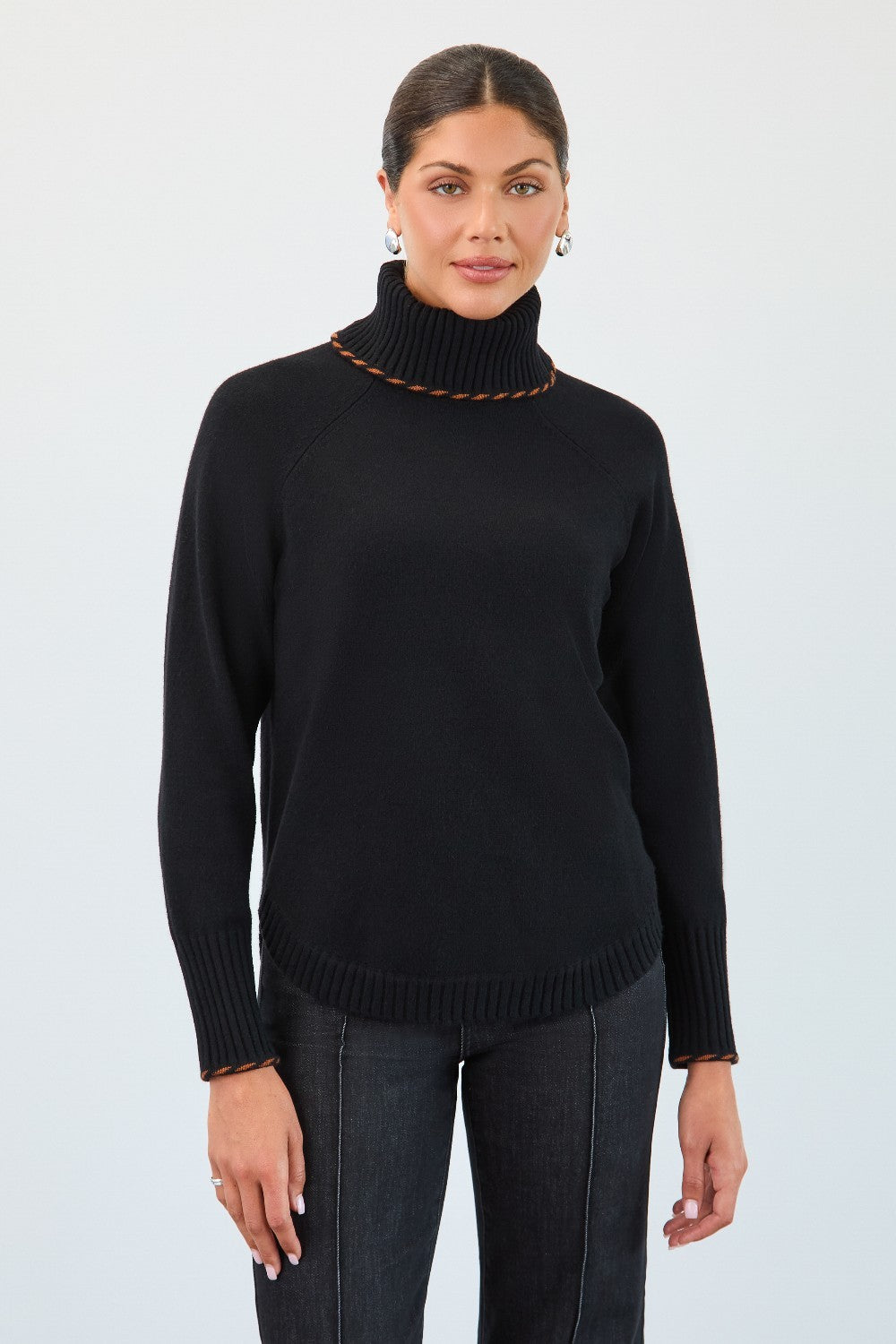 Woman wearing a black turtleneck sweater against a white background