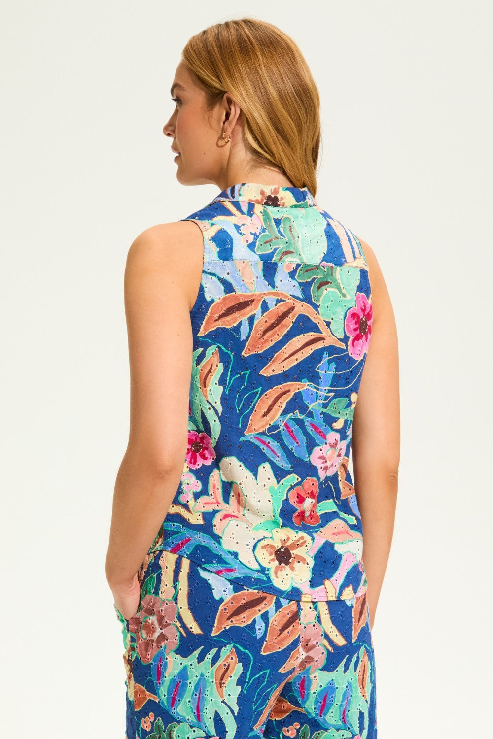 Flaunt your vibrant style with the FDJ Printed Eyelet Sleeveless Top. Made of 100% cotton, this top is both comfortable and chic. Its bright and cheery floral design adds a touch of playfulness to any outfit. Perfect for those who don't take themselves too seriously.