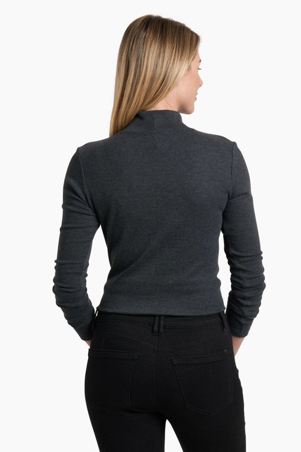 Woman wearing a dark gray long-sleeve top and black pants on a white background