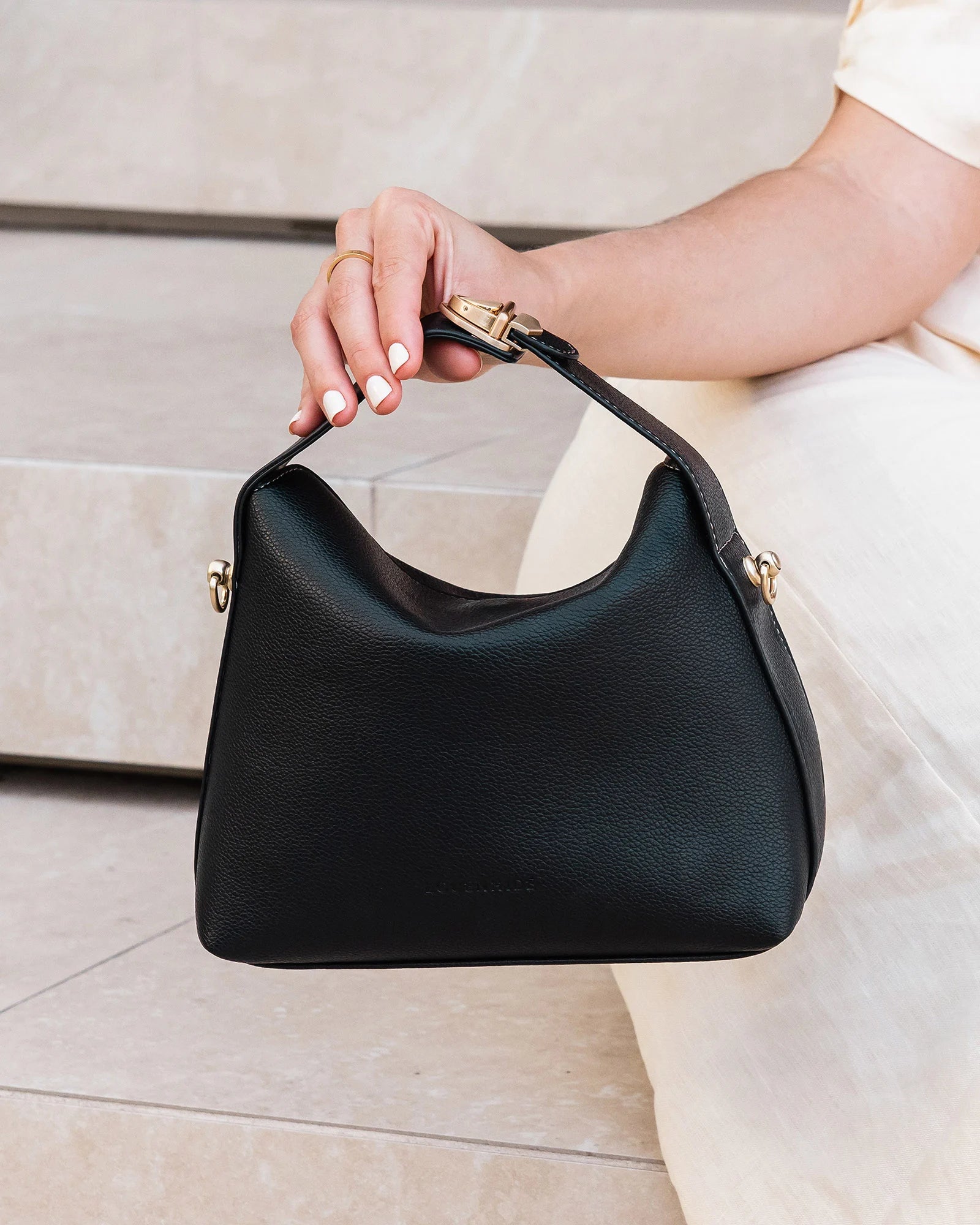 The Louenhide Andie Handbag is this season's go-to event bag. Add an element of playful luxury to your event attire with this sweet and slouchy clutch bag. Designed with a clever minimalistic fold-over closure and two piece clasped handle in a gorgeous trapeze shape, this convertible women's handbag is the perfect way to inject colour into your summer wardrobe. Loop the Andie over your wrist or, for a handsfree moment, attach the adjustable bag strap to wear as a crossbody bag. Showcasing a spacious interio