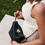 The Louenhide Andie Handbag is this season's go-to event bag. Add an element of playful luxury to your event attire with this sweet and slouchy clutch bag. Designed with a clever minimalistic fold-over closure and two piece clasped handle in a gorgeous trapeze shape, this convertible women's handbag is the perfect way to inject colour into your summer wardrobe. Loop the Andie over your wrist or, for a handsfree moment, attach the adjustable bag strap to wear as a crossbody bag. Showcasing a spacious interio