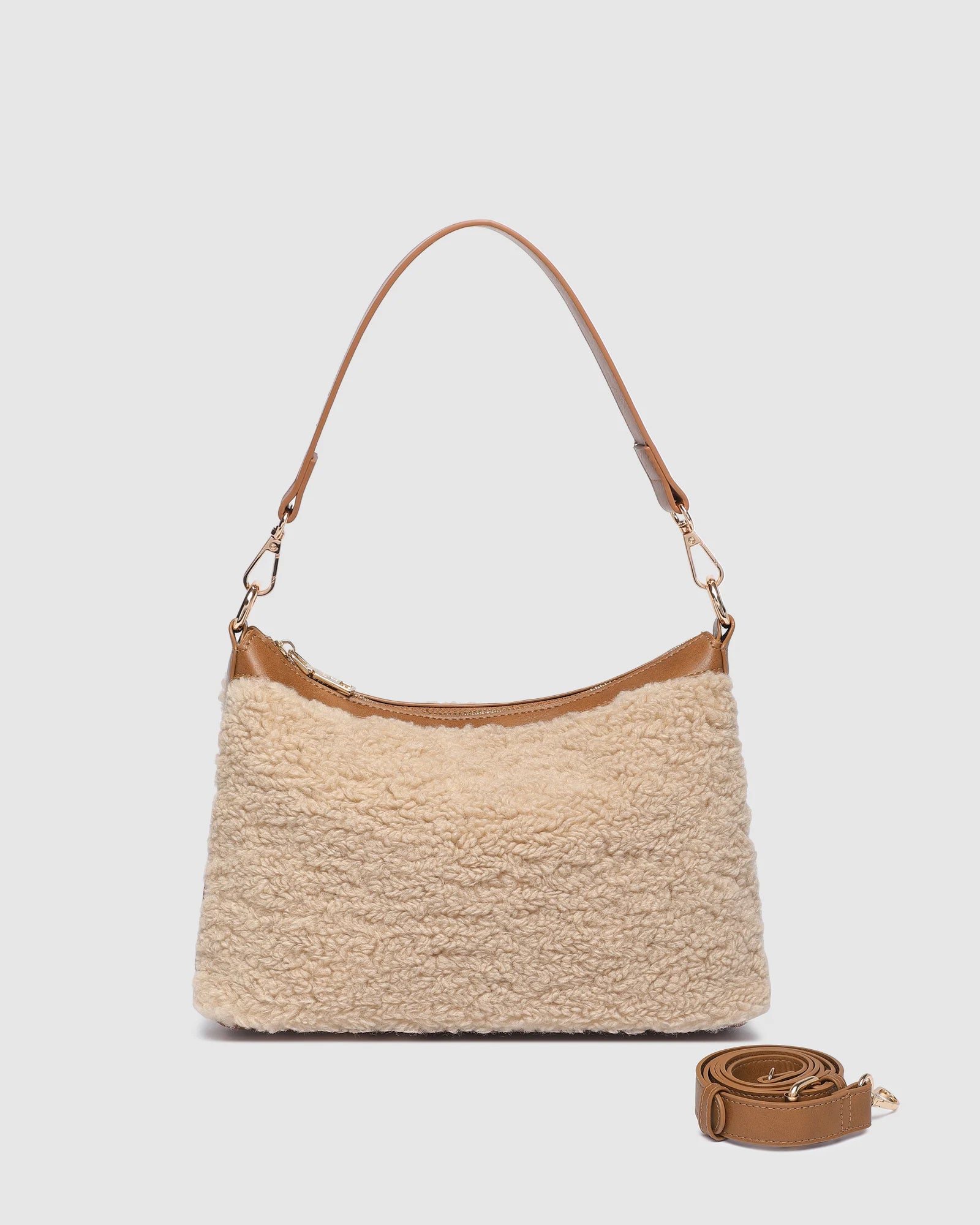 The Louenhide Aspen Shoulder Bag is the soft-structured silhouette your winter wardrobe’s been waiting for. Crafted in a faux shearling texture with warm neutral tones, this sherpa bag brings a subtle warmth to cool-weather dressing. Light gold hardware adds a refined touch to this beige shoulder bag, while the spacious interior easily fits your daily essentials. Whether styled with denim or layered with flowing silhouettes, the Aspen is designed to move with you through the season - statement, elevated, an