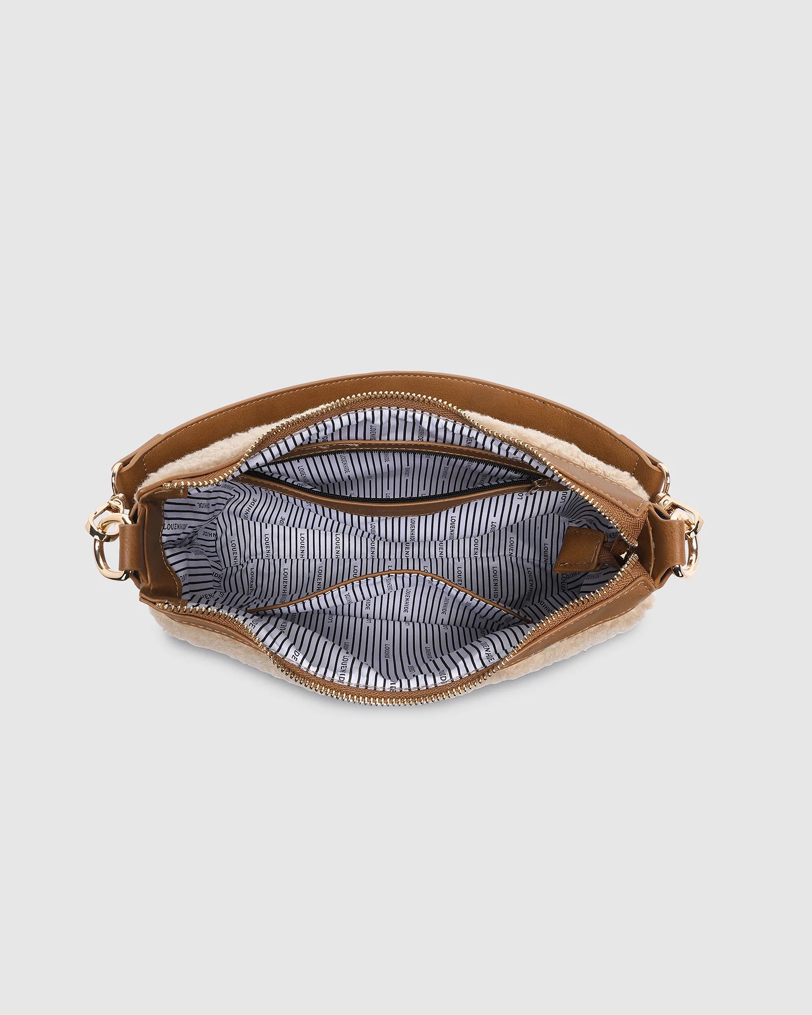 The Louenhide Aspen Shoulder Bag is the soft-structured silhouette your winter wardrobe’s been waiting for. Crafted in a faux shearling texture with warm neutral tones, this sherpa bag brings a subtle warmth to cool-weather dressing. Light gold hardware adds a refined touch to this beige shoulder bag, while the spacious interior easily fits your daily essentials. Whether styled with denim or layered with flowing silhouettes, the Aspen is designed to move with you through the season - statement, elevated, an