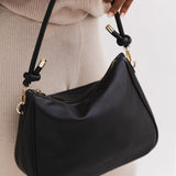 The Louenhide Baby Remi Shoulder Bag is a classic women's everyday bag with elevated style. Designed in a soft and slouchy silhouette with smooth vegan leather, this casual hobo bag is sure to turn heads with its timeless knot detailing strap feature.