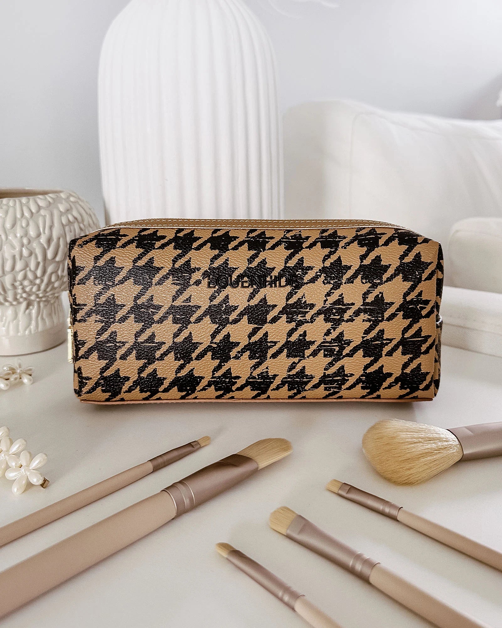 The Louenhide Brianna Makeup Bag is the perfect addition to your beauty routine. Exude style on your next adventure with the visually captivating camel and black houndstooth pattern. Complete with a set of makeup brushes, this women’s small makeup bag is the perfect size for travel.