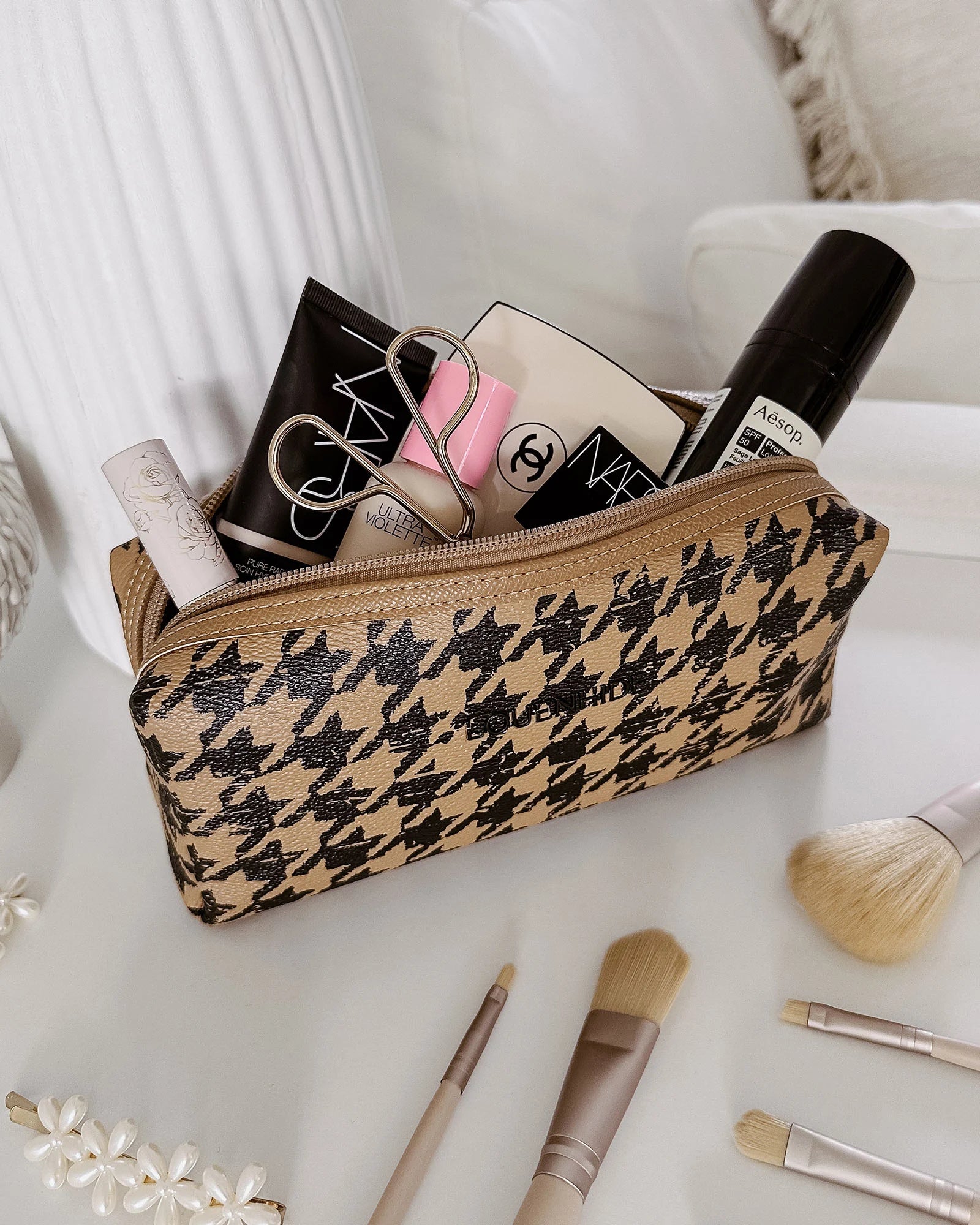 The Louenhide Brianna Makeup Bag is the perfect addition to your beauty routine. Exude style on your next adventure with the visually captivating camel and black houndstooth pattern. Complete with a set of makeup brushes, this women’s small makeup bag is the perfect size for travel.