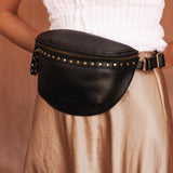 The Louenhide Cassidy Belt Bag is a bold staple designed to add a statement finish to your everyday styling. Crafted in a structured faux leather and adorned with refined hardware accents, this studded bag blends functionality with elevated design. The curved silhouette sits comfortably against the body, while the adjustable strap offers the option to wear it as a classic belt bag or crossbody style - making it one of the best sling bag options for hands-free ease. Compact yet roomy enough for your on-the-g