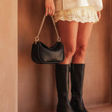 The Louenhide Saylor Crossbody Bag brings a bold yet refined edge to your everyday styling in a soft vegan leather finish. A sleek baguette-shaped silhouette, this cross body bag with chain detailing blends texture and refinement in all the right ways. Designed to be worn with ease but styled to stand out, the Saylor Black moves effortlessly from day to night, adding impact to your layered winter looks. Wherever the day leads, this chain strap handbag is the finishing touch that completes the look.