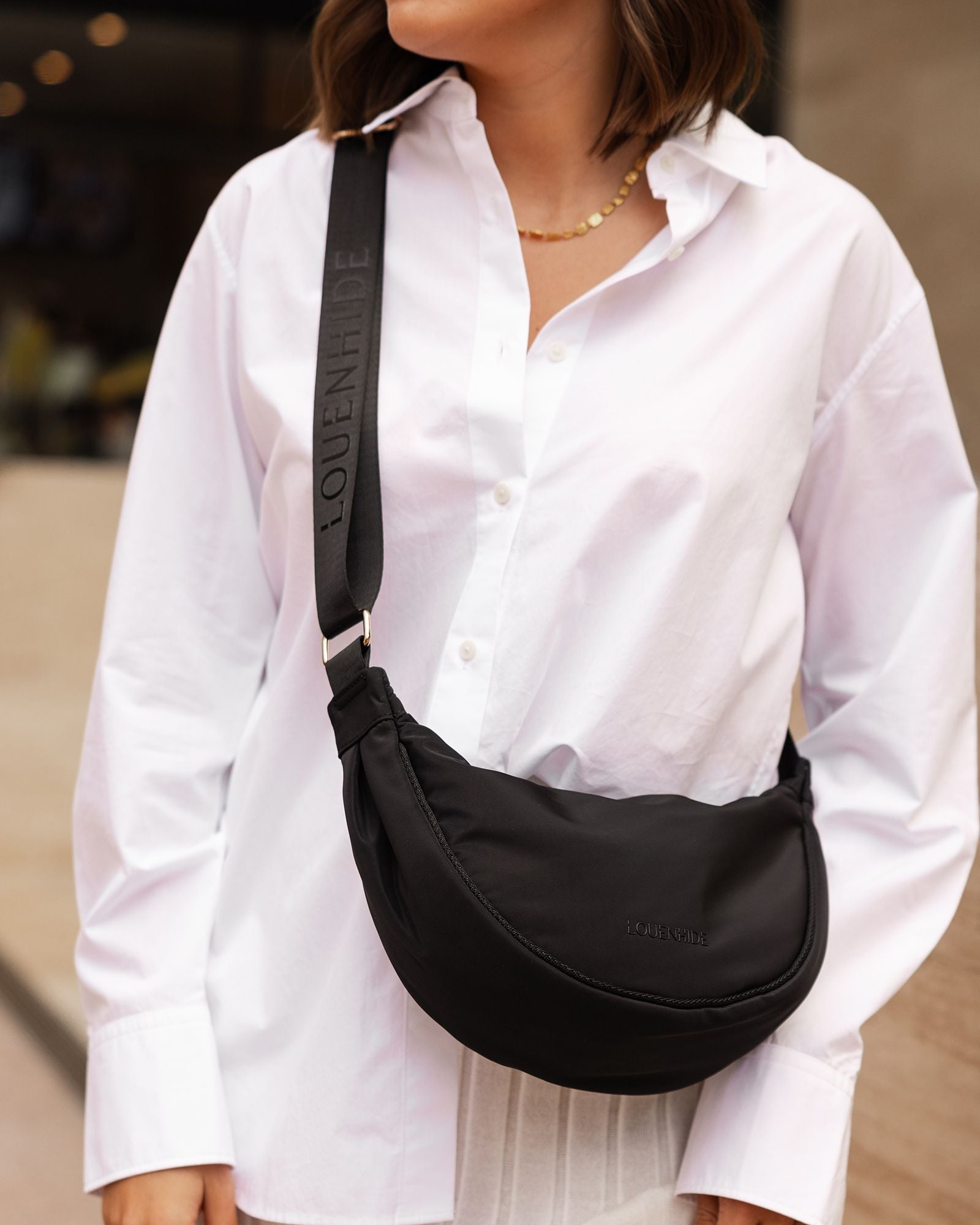 The Louenhide Sylvia Nylon Crossbody Bag is an on-trend style, featuring a modern crescent silhouette.