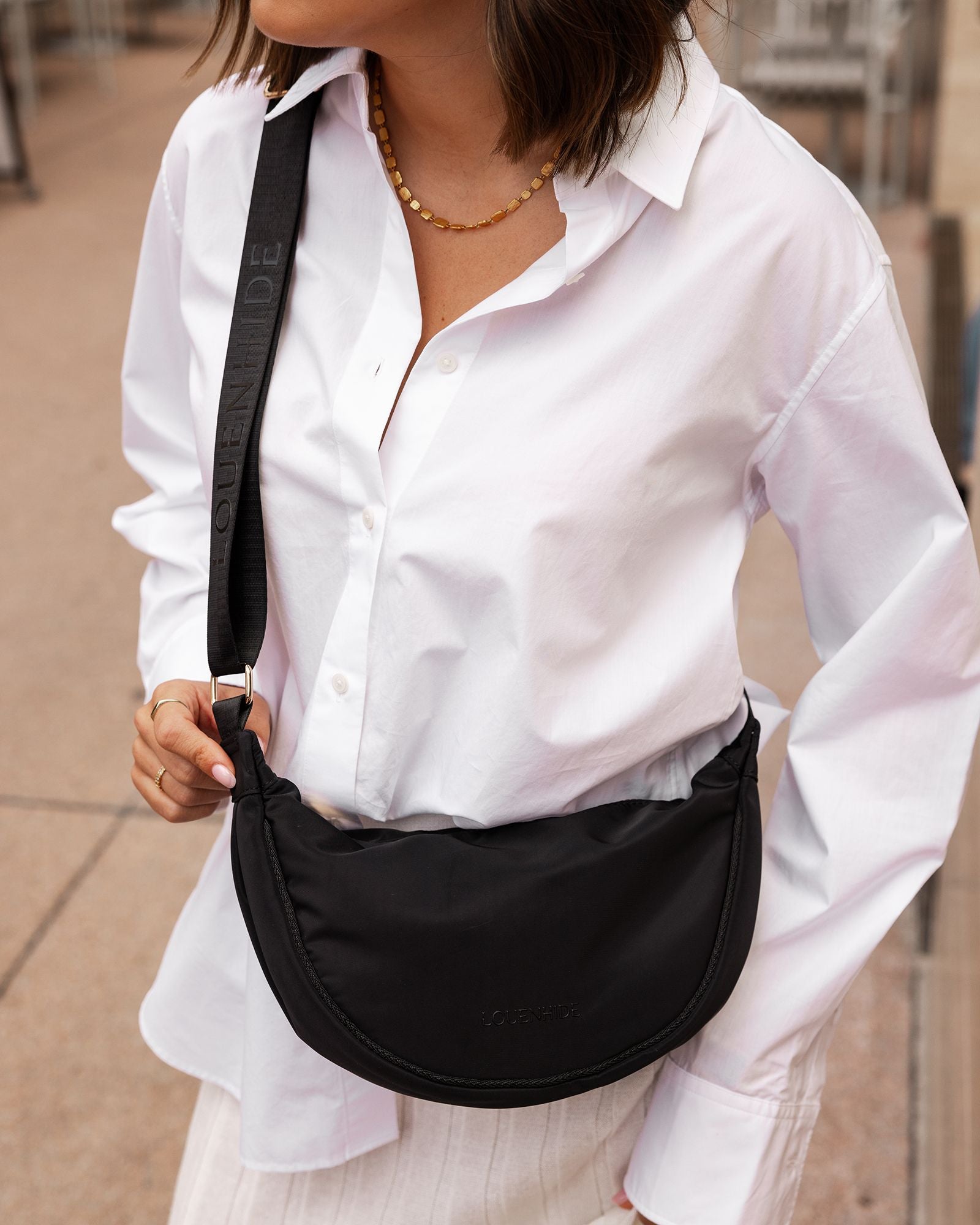 The Louenhide Sylvia Nylon Crossbody Bag is an on-trend style, featuring a modern crescent silhouette.