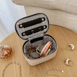 The Louenhide Trudy Jewelry Box is the perfect solution to keeping your valuables safely organized on the go. This compact travel jewelry case fits seamlessly into your luggage without taking up space. The secure zip closure ensures your jewelry stays protected, while the textured raffia and contrasting faux leather exterior add a touch of understated luxury to your travel style.