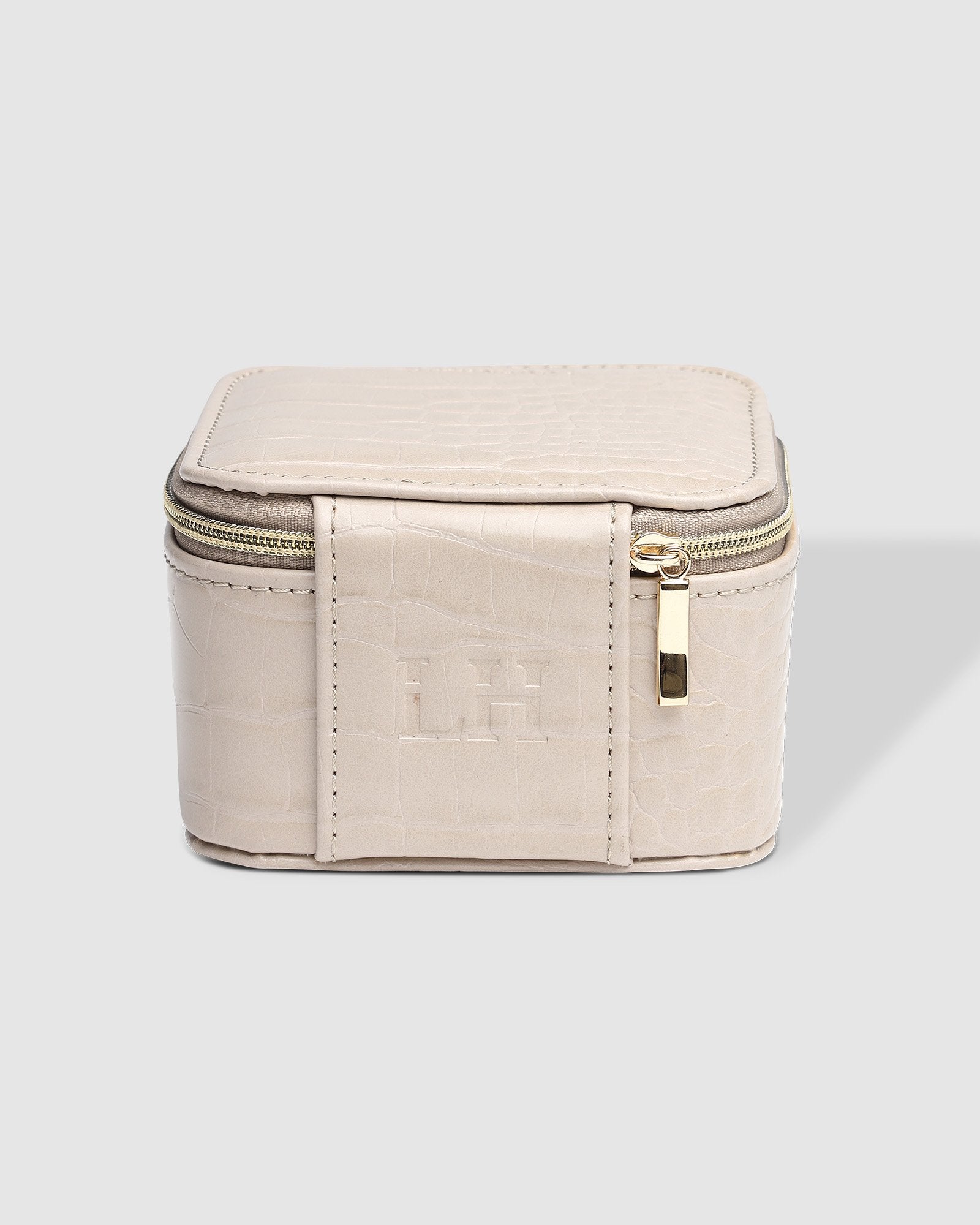 The Louenhide Beau Jewelry Box is a small, square jewellery organizer designed to keep your pieces safe and secure at home or when you are on the go. Featuring a vegan croc exterior, the Beau is every woman's dream jewelry case! Store your larger pieces in the main compartment, while safely stowing your smaller jewels in the elasticated slip pocket
