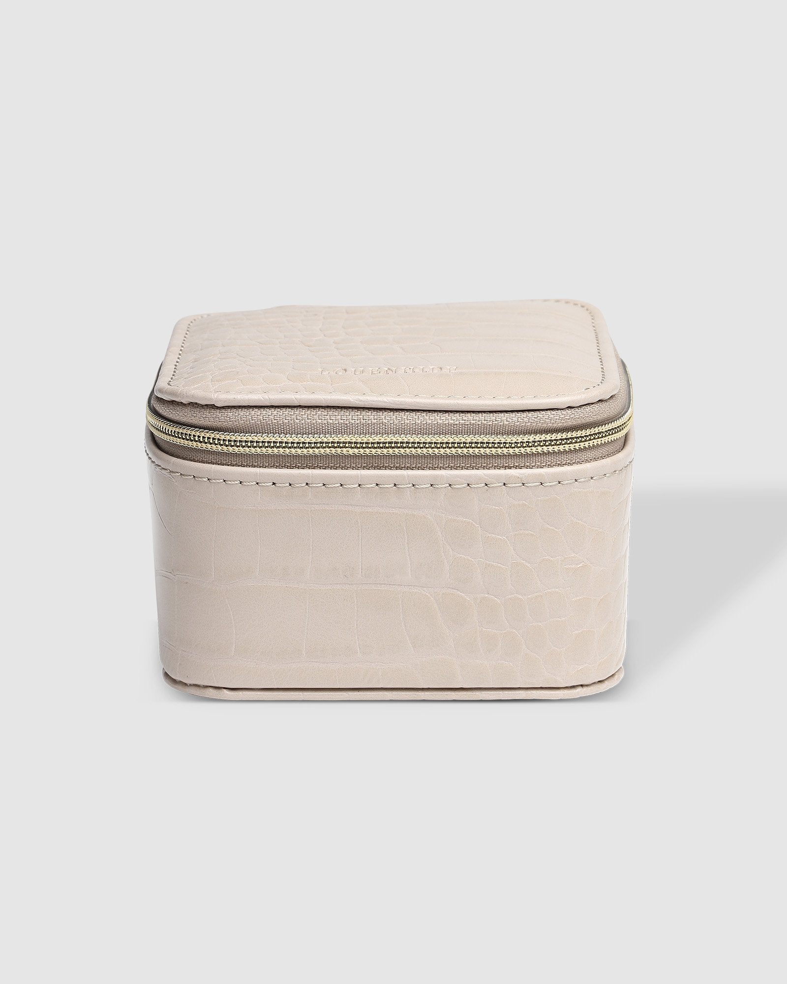 The Louenhide Beau Jewelry Box is a small, square jewellery organizer designed to keep your pieces safe and secure at home or when you are on the go. Featuring a vegan croc exterior, the Beau is every woman's dream jewelry case! Store your larger pieces in the main compartment, while safely stowing your smaller jewels in the elasticated slip pocket