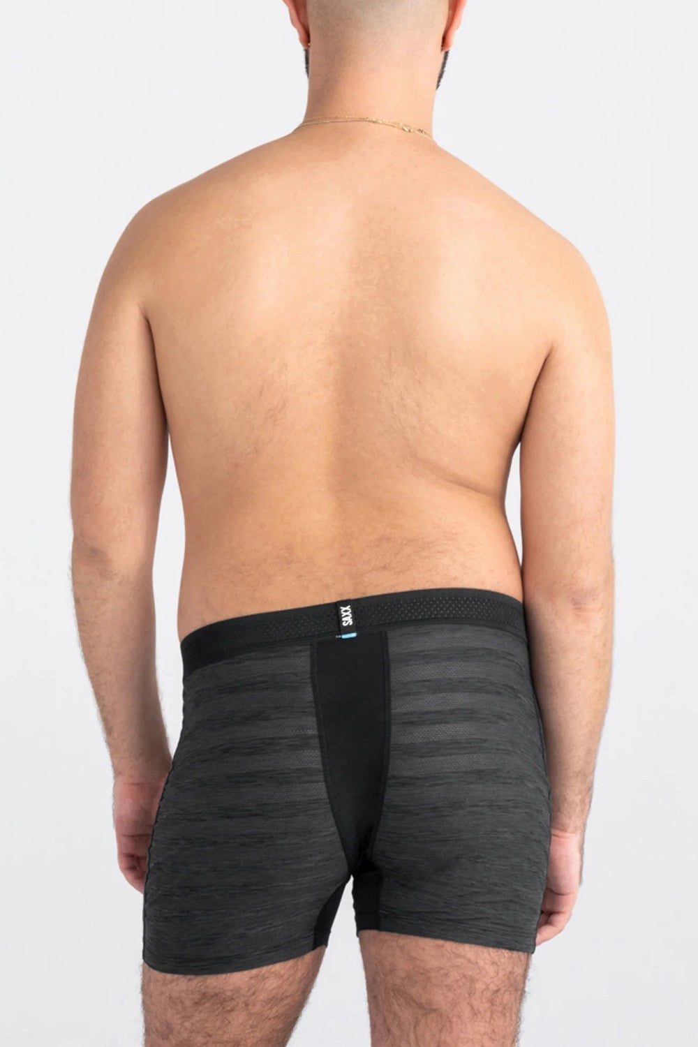 Person wearing black boxer briefs on a plain background