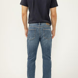 Person wearing blue jeans and a black t-shirt on a white background