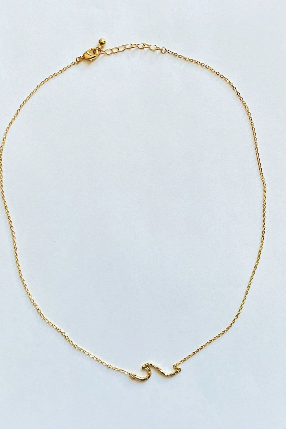 Ride the wave with this Chainlink Necklace featuring a handmade wave pendant. Gold plated for a delicate touch, this necklace is perfect for any occasion.