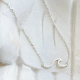 Ride the wave with this Chainlink Necklace featuring a handmade wave pendant. Silver plated for a delicate touch, this necklace is perfect for any occasion.
