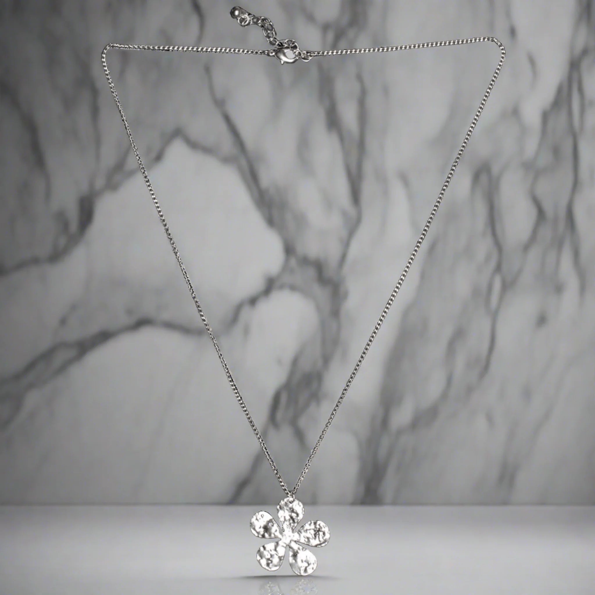Add a touch of whimsy to your wardrobe with our Hammered Flower Pendant On Chain. Each silver plated pendant features a unique floral design, making it the perfect accessory for any outfit.