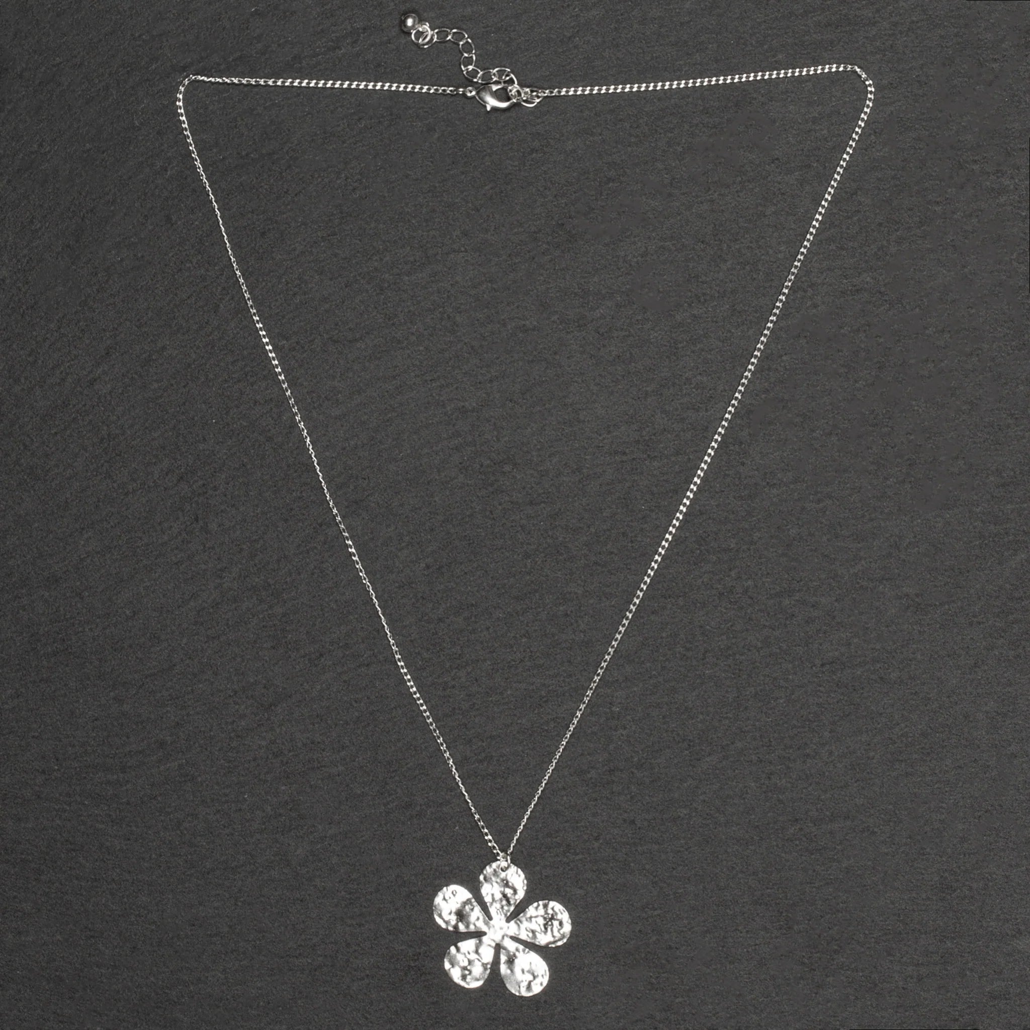 Add a touch of whimsy to your wardrobe with our Hammered Flower Pendant On Chain. Each silver plated pendant features a unique floral design, making it the perfect accessory for any outfit.