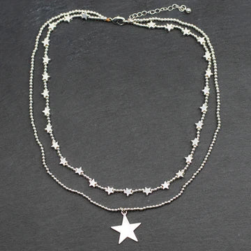 Delight in the beauty of the Suzie Blue Silver Plate Double Strand Star Charm Necklace.
