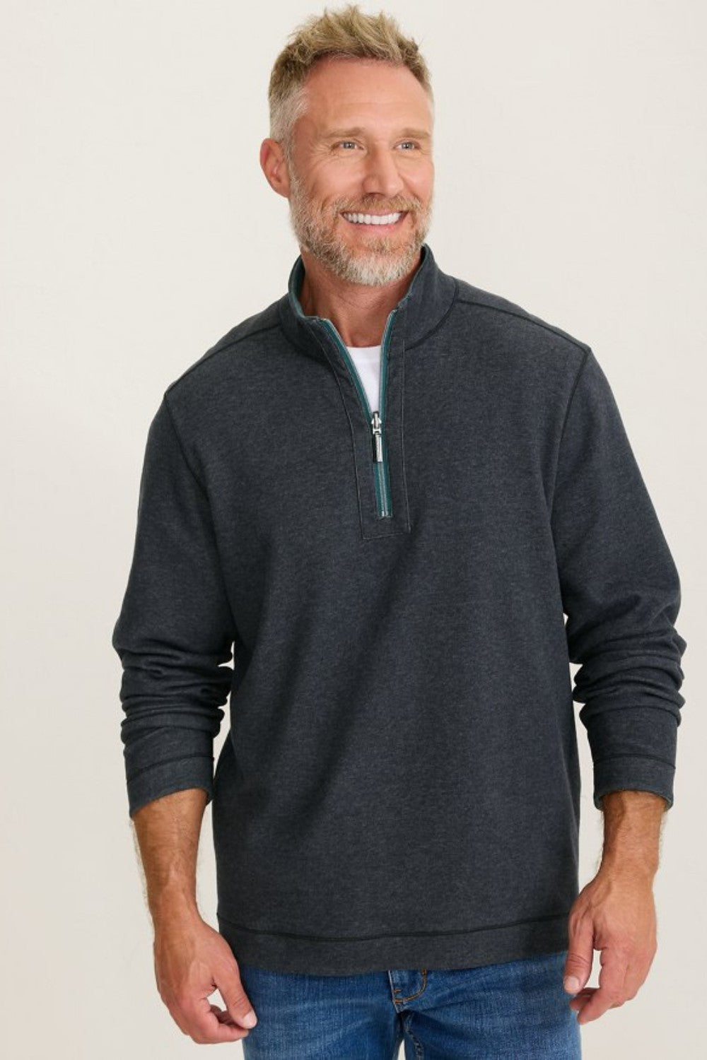 Man wearing a dark gray zip-up sweatshirt against a plain background