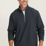 Man wearing a dark gray zip-up sweatshirt against a plain background