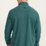 Man wearing a green fleece pullover with a logo on the back against a white background