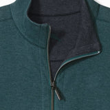 Close-up of a green pullover with a zipper collar on a white background