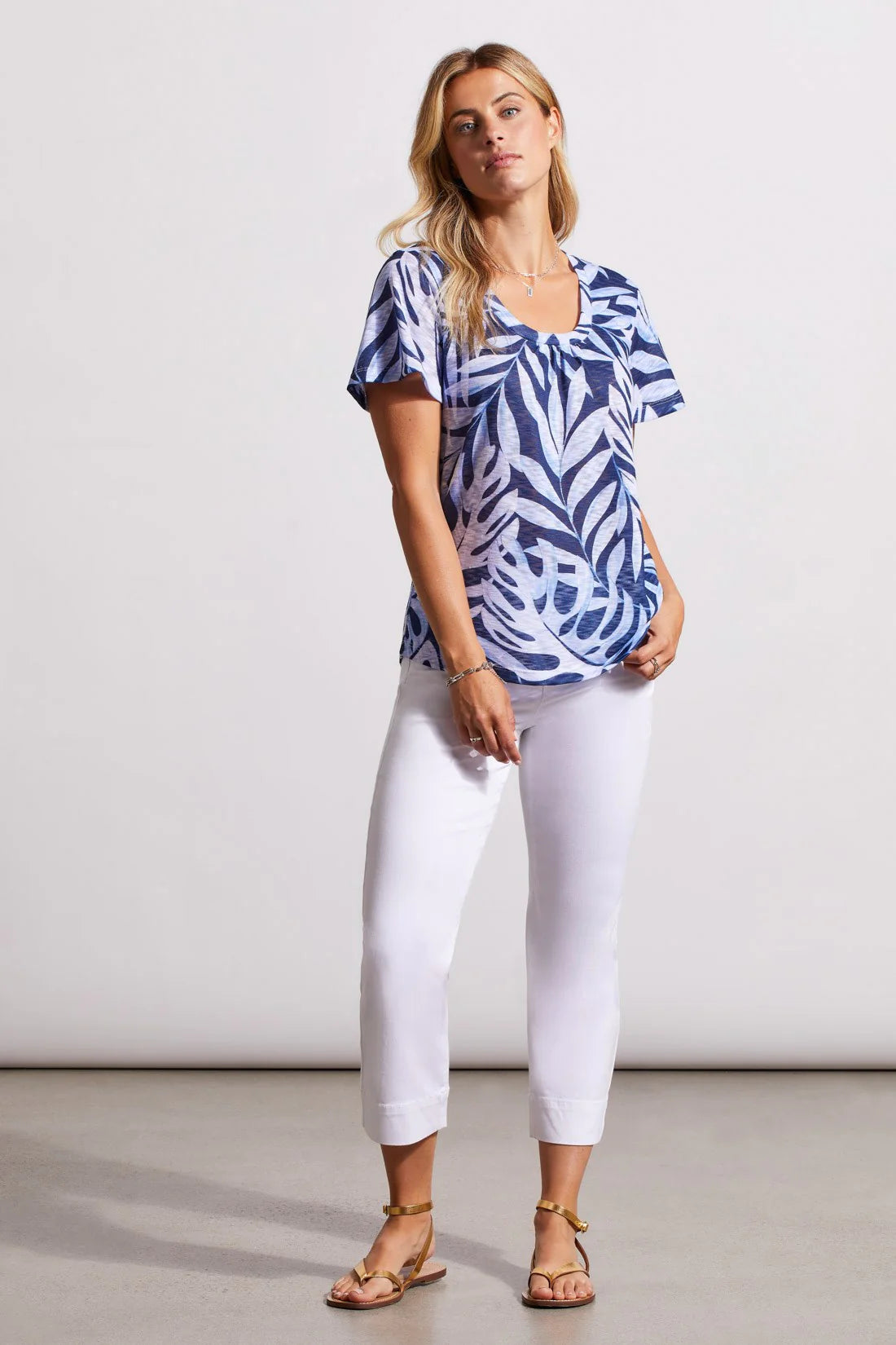 We know you'll love this flirty top as much as we do. Flutter sleeves and a U-shaped neckline add to neck shirring and a curved hem. The soft printed knit keeps thing slight and flowy.