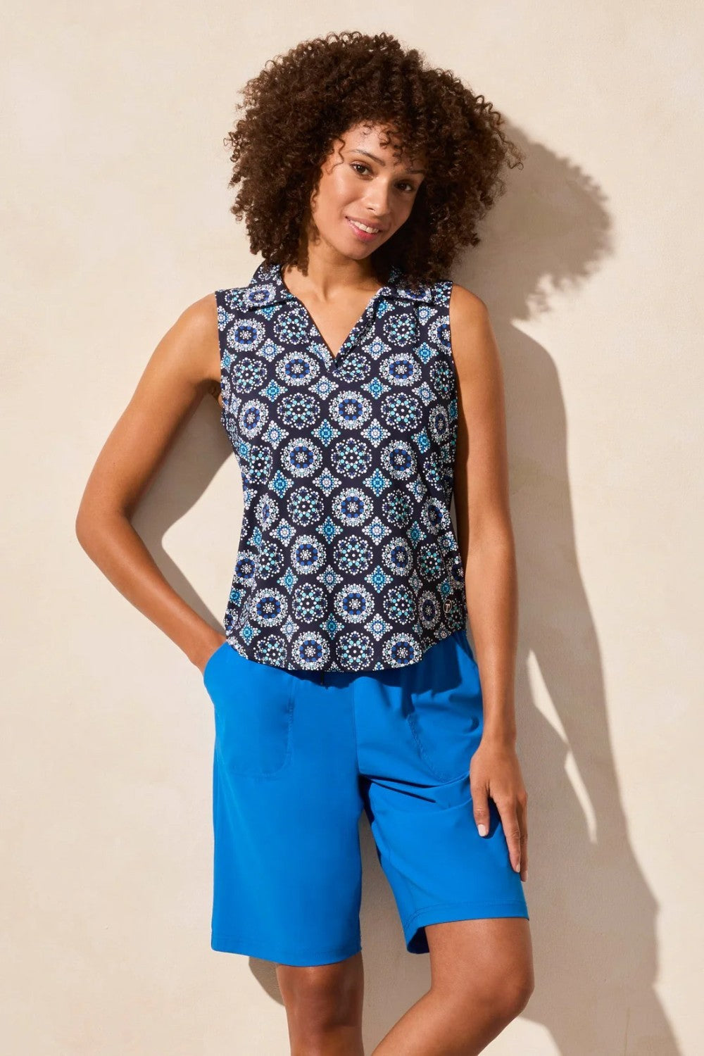 Elevate your style with this polo top featuring an eye-catching textured print. The sleeveless design keeps you cool on warmer days, while the shirttail finish offers a draped look that makes it easy to tuck in.